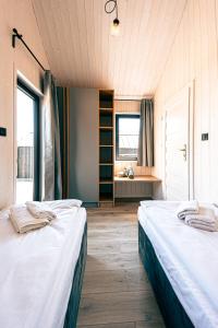 2 camas en una habitación con 2 ventanas en Wynki no. 69 en Łukta