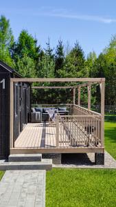 a wooden deck with a gazebo in the grass at Wynki no. 69 in Łukta +25 photos