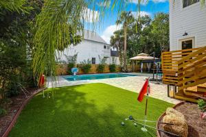un patio con piscina y putting green en The Gatsby Mansion Heated Pool Heart of Town en St. Augustine