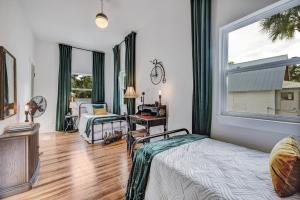 a bedroom with a bed and a desk and a window at The Gatsby Mansion Heated Pool Heart of Town in St. Augustine