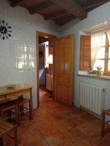 Zimmer mit einer Tür, einem Tisch und einem Fenster in der Unterkunft Casa Villastur in Covadonga