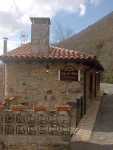 ein kleines Steingebäude mit einem Schild darauf in der Unterkunft Casa Villastur in Covadonga