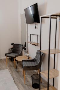 um quarto com duas cadeiras e uma mesa e uma televisão em No. 55 em Buzau