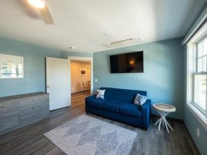 a living room with a blue couch and a table at Long Beach Suites in Gloucester