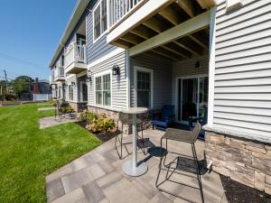 a patio with chairs and a table on a house at Long Beach Suites in Gloucester