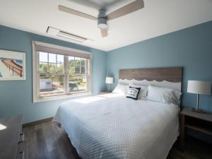 a bedroom with a large bed with blue walls at Long Beach Suites in Gloucester
