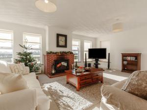 a living room with a fireplace and a tv at Highgrove in Gissing
