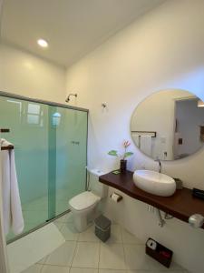 uma casa de banho com um WC, um lavatório e um espelho. em Ao Mar - Hospedagem em São Sebastião