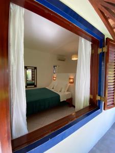 Blick auf ein Schlafzimmer durch ein Fenster in der Unterkunft Ao Mar - Hospedagem in São Sebastião