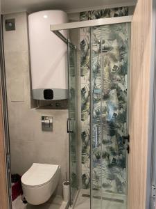 a bathroom with a toilet and a glass shower stall at Dream_Apartment in Varna City