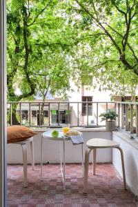 a table and chairs on a balcony with trees at Sunny Suites Lisbon in Lisbon