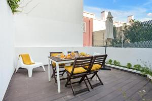 a dining table and chairs on a patio at Modern 2 Bedroom Apartment in Estrela with Outside Terrace! Amazing for Families, Couples, Friends in Lisbon