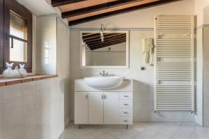 Baño blanco con lavabo y espejo en Casa Vecchia Rooms and Parking, en Gambassi Terme