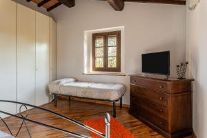 sala de estar con TV y tocador con cama en Casa Vecchia Rooms and Parking, en Gambassi Terme