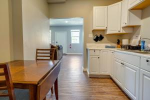 a kitchen with white cabinets and a wooden table at Zanesville Vacation Rental Near Downtown in Zanesville