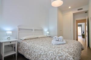 ein Schlafzimmer mit einem Bett mit zwei Handtüchern darauf in der Unterkunft Apartamento San Leonardo Playa (Free Parking) in Cádiz