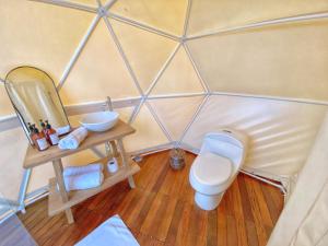 a bathroom with a toilet and a mirror at Bohemia Glamping 