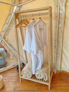 a shelf with a white shirt and towels on it at Bohemia Glamping 