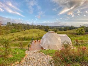 a large tent in a field on a hill at Bohemia Glamping 