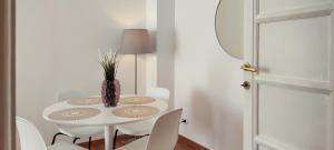 a white table with white chairs and a vase on it at a pochi passi da Trastevere in Rome