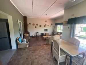 a living room with a table and chairs at Reed Mat Lodge, Furnished Stand-alone 4 bedroomed house in Lusaka