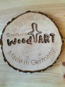a wood art sign on a wooden table at Campingfässer Weener in Weener