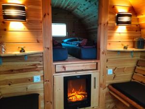 una sala de estar con chimenea en una casa pequeña en Campingfässer Weener en Weener