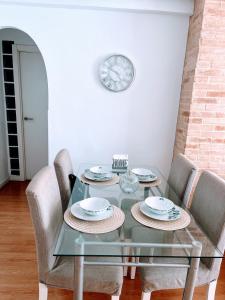 Valencia Apartament Encantador في فالنسيا: غرفة طعام مع طاولة وكراسي زجاجية