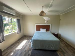 盧薩卡的住宿－Reed Mat Lodge, Furnished Stand-alone 4 bedroomed house，一间卧室设有一张床和一个大窗户