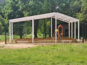 a pavilion with a playground in a park with benches at Apartamentos Gallaecia in Val do Dubra
