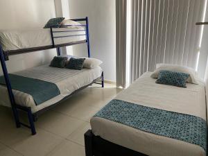 Divstāvu gulta vai divstāvu gultas numurā naktsmītnē Apartamentos Frente a La Playa Boca del Rio