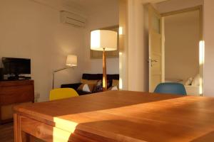 uma sala de estar com mesa e cadeiras em Central 2 bedroom apt w/Garden and Pantheon Views em Lisboa