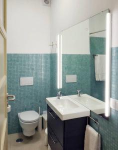 uma casa de banho com um lavatório, um WC e um espelho. em Central 2 bedroom apt w/Garden and Pantheon Views em Lisboa