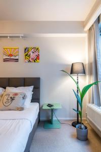 1 dormitorio con 1 cama y una maceta en Japie rooms - in the heart of Antwerp, en Amberes