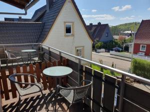 a balcony with tables and chairs and a house at Haus Drei Seen in Walkenried