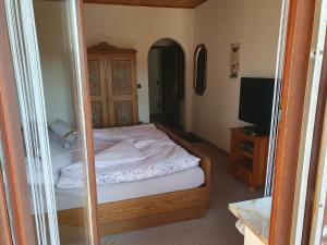 - une petite chambre avec un lit et une télévision dans l'établissement Haus Drei Seen, à Walkenried