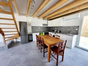 uma cozinha com uma mesa de madeira e cadeiras em Maison Confort et détente em Tavaco