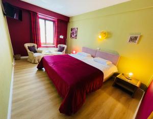 - une chambre avec un grand lit et une couverture rouge dans l'établissement Hostellerie Sainte-Cécile, à Florenville