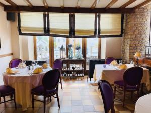 a dining room with two tables and purple chairs at Hostellerie Sainte-Cécile in Florenville