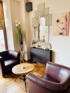 a living room with two chairs and a table at Hostellerie Sainte-Cécile in Florenville