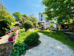 een tuin met een tafel, stoelen en planten bij Hostellerie Sainte-Cécile in Florenville
