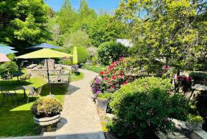 a garden with tables and chairs and flowers at Hostellerie Sainte-Cécile in Florenville