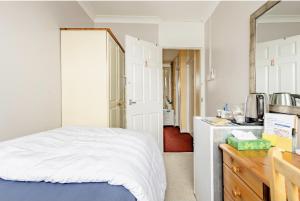 sypialnia z białym łóżkiem i kuchnią w obiekcie Exclusive rooms w Londynie