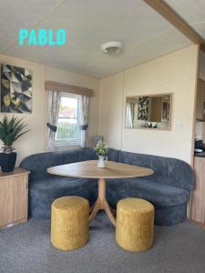 a living room with a blue couch and a table at 2 Bedroom 6 berth Caravan Towyn Rhyl in Rhyl