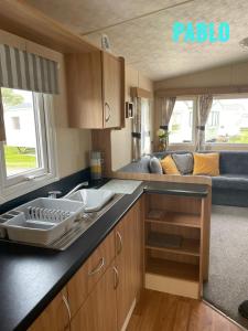 an rv kitchen with a sink and a couch at 2 Bedroom 6 berth Caravan Towyn Rhyl in Rhyl