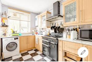 kuchnia z kuchenką i pralką w obiekcie Exclusive rooms w Londynie