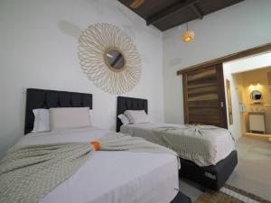 a bedroom with two beds and a mirror on the wall at Villas El Beach Club in Santa Cruz