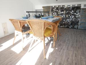 uma mesa de jantar com cadeiras de vime num quarto em L'Oriflamme em Avignon