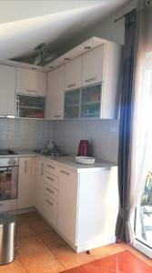 a kitchen with white cabinets and a window at Apartment Franka in Sveti Vid-Miholjice