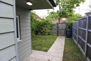 a backyard with a fence and a walkway next to a house at Beautiful private detached 1 bed with private outdoor space in Stone Grove